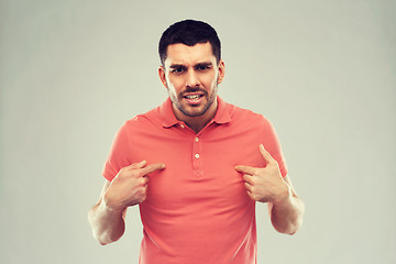 Image showing angry man pointing finger to himself over gray