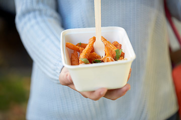 Image showing close up of hand holding plate with sweet potato