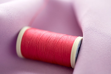 Image showing red thread spool on cloth