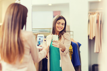 Image showing woman taking mirror selfie by smartphone at store