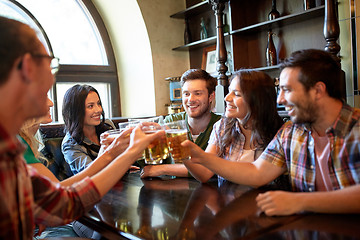 Image showing happy friends drinking beer at bar or pub