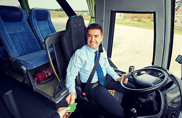 Image showing bus driver taking ticket or card from passenger