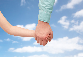 Image showing father and child holding hands over blue sky