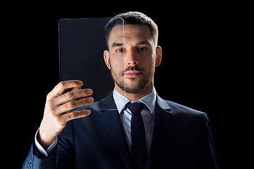 Image showing businessman in suit working with transparent tablet pc