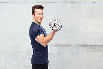 Image showing happy sportive young man with dumbbell