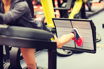 Image showing woman flexing muscles on leg press machine in gym
