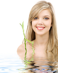 Image showing blue-eyed blonde with bamboo in water