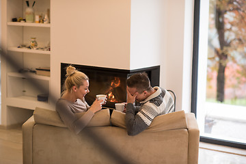 Image showing Young couple  in front of fireplace