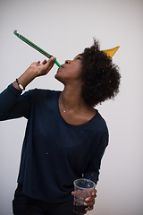 Image showing black woman in party hat blowing in whistle