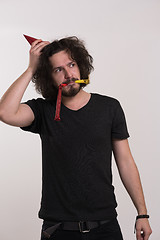 Image showing Portrait of a man in party hat blowing in whistle