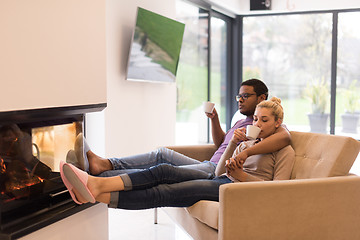 Image showing Young multiethnic couple  in front of fireplace