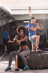 Image showing multiethnic couple after workout with hammer