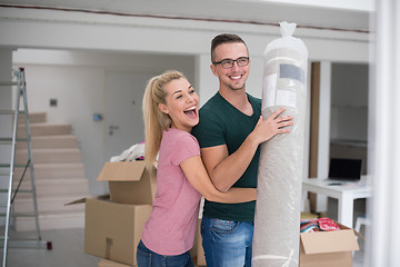 Image showing couple carrying a carpet moving in to new home