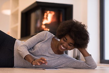 Image showing black women using tablet computer on the floor