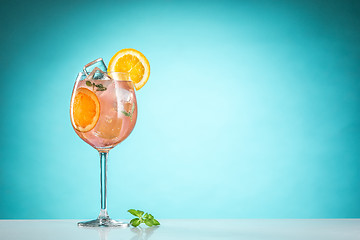 Image showing The rose exotic cocktail and fruit on blue