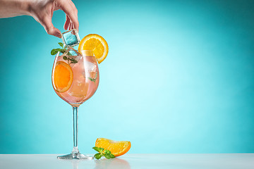 Image showing The rose exotic cocktail and fruit on blue