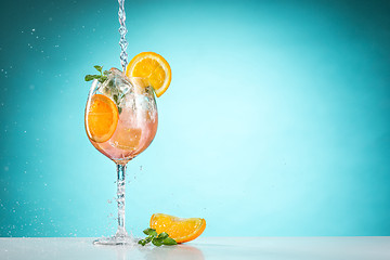 Image showing The rose exotic cocktail and fruit on blue