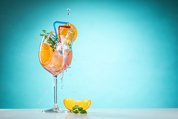 Image showing The rose exotic cocktail and fruit on blue