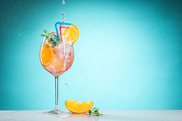 Image showing The rose exotic cocktail and fruit on blue