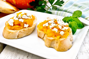 Image showing Bruschetta with pumpkin and feta in white plate on board