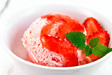 Image showing Ice cream strawberry with syrup in bowl on board