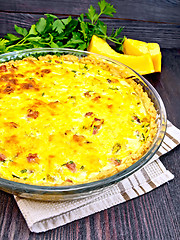 Image showing Quiche with pumpkin and bacon in pan on dark board