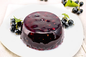 Image showing Jelly from black currant with berries in plate on napkin