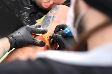 Image showing Color tattoo inks. A tattoo artist tattooing color tattoo Making tattoo