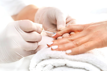 Image showing Manicure white nail polish. beautician painting nails