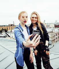 Image showing two cool blond real girls friends making selfie on roof top, lif