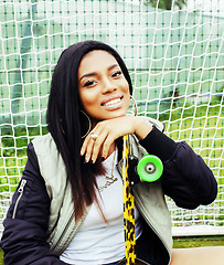 Image showing cool pretty smiling afro-american happy young woman with skate b