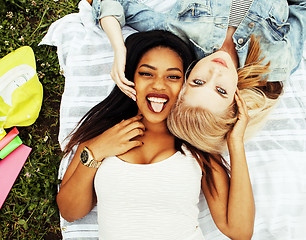 Image showing two young pretty teenager girls best friends laying on grass mak