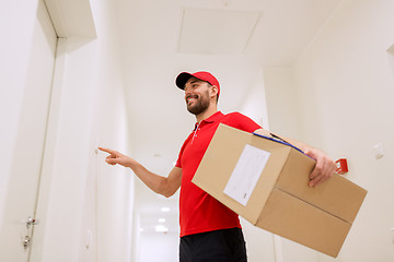 Image showing delivery man with parcel box ringing doorbell