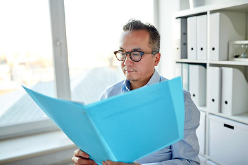 Image showing businessman with folder and papers at office