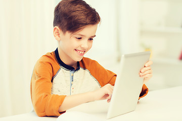 Image showing smiling boy with tablet pc computer at home