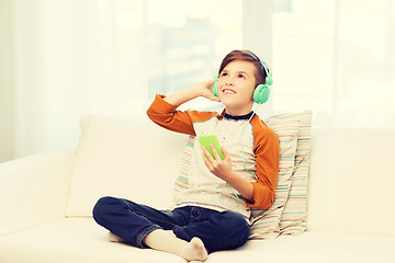 Image showing happy boy with smartphone and headphones at home