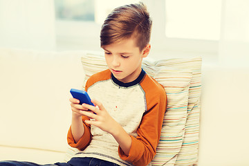 Image showing boy with smartphone texting or playing at home