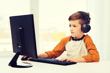 Image showing happy boy with computer and headphones at home