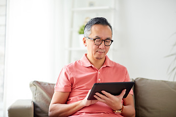 Image showing man with tablet pc sitting on sofa at home