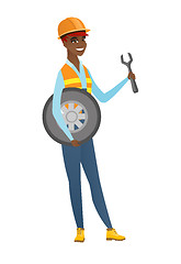 Image showing Young mechanic with tyre and spanner.