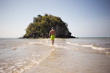 Image showing Young man walks by seashore