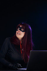 Image showing Smiling brunette bandit with laptop