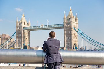 Image showing British businessman talking on mobile phone outdoor in London city, UK.