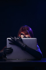 Image showing Hacker in mask holds laptop