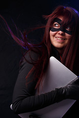 Image showing Brunette in mask holds laptop