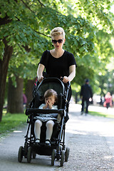 Image showing mother pushed her baby daughter in a stroller