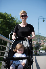 Image showing mother pushed her baby daughter in a stroller