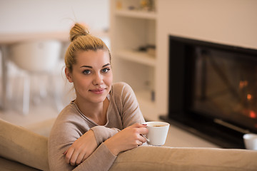 Image showing woman with a mug near a fireplace