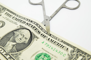 Image showing Scissors cut through a dollar bill