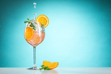 Image showing The rose exotic cocktail and fruit on blue